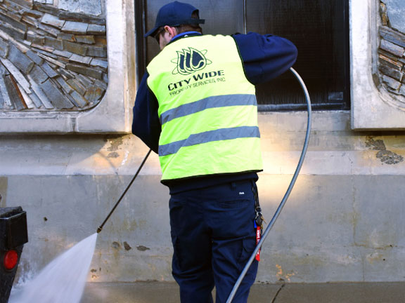 Close-up of a pressure washing hose removing paint